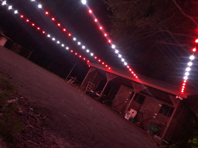 Red and white string lighting running the length of a barn