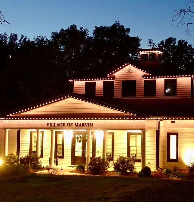 A lit civic porch with a Christmas wreath