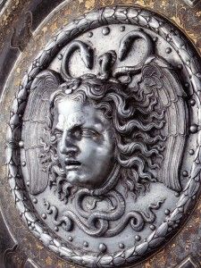 Gargoyle face of male with wavy hair.