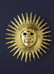 Iron sculpture representing the sun with face in center.