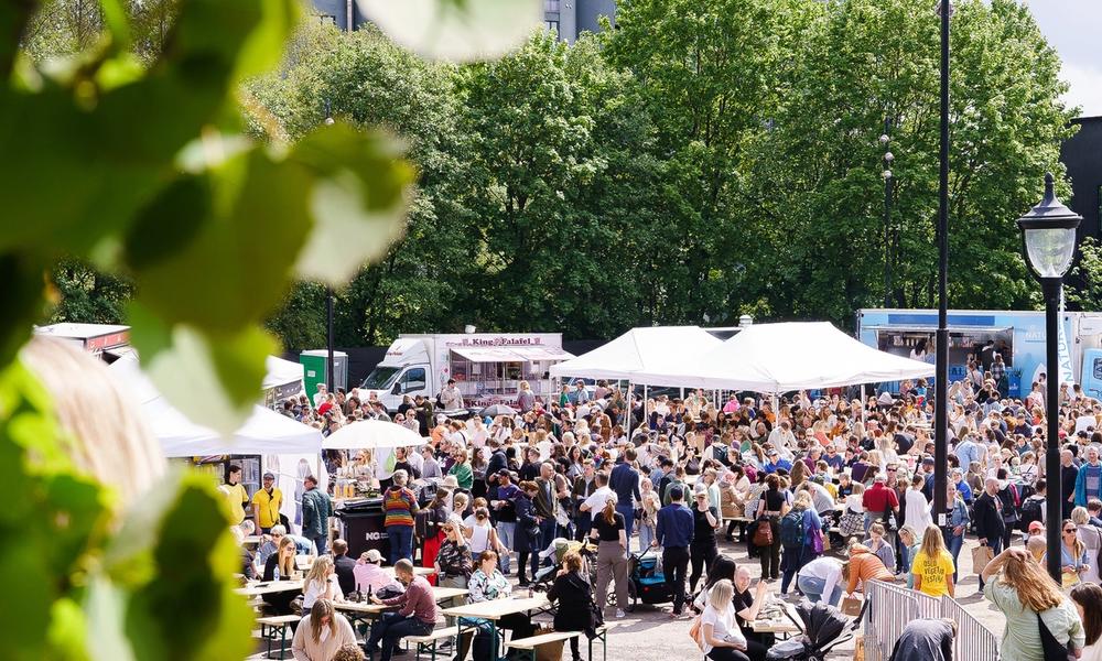 Oversiktbilde av matområdet på Oslo Vegetarfestival med food trucks og mye folk.