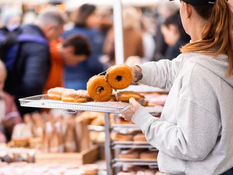 Bilde av ansatt som selger donuts på et marked