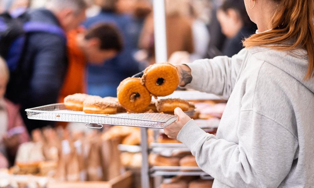 Bilde av ansatt som selger donuts på et marked