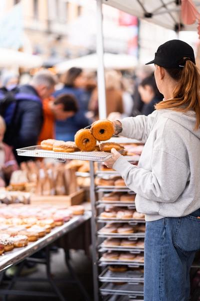 Bilde av ansatt som selger donuts på et marked