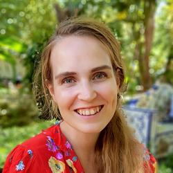 Bilde av Frida Felicia Vennerød-Diesen foran grønne planter.