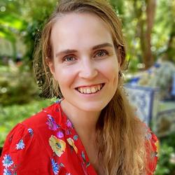 Bilde av Frida Felicia Vennerød-Diesen foran grønne planter.