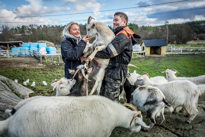 Anette og Andreas fra Dale Store gård står sammen med en gjeng geiter.
