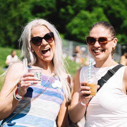 Bilde av to fornøyde festivaldeltagere med drikke