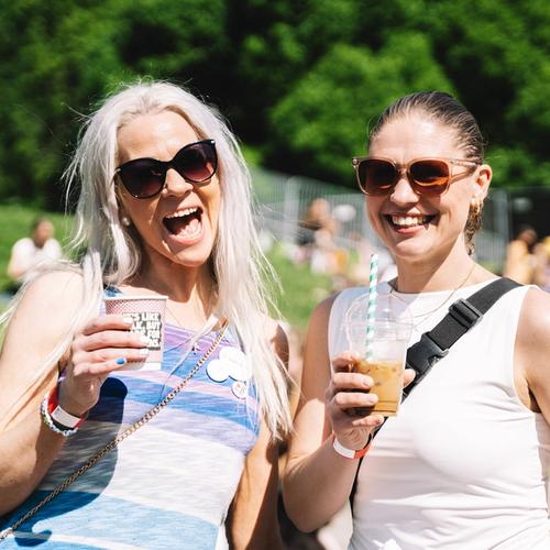 Bilde av to fornøyde festivaldeltagere med drikke