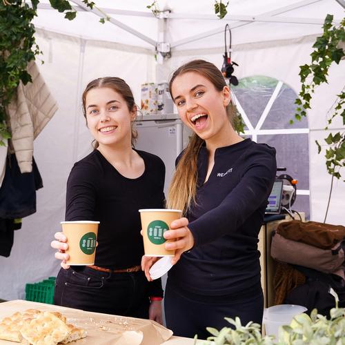 Bilde av to fornøyde utstillere på Oslo Vegetarfestival med hver sin kaffekopp.