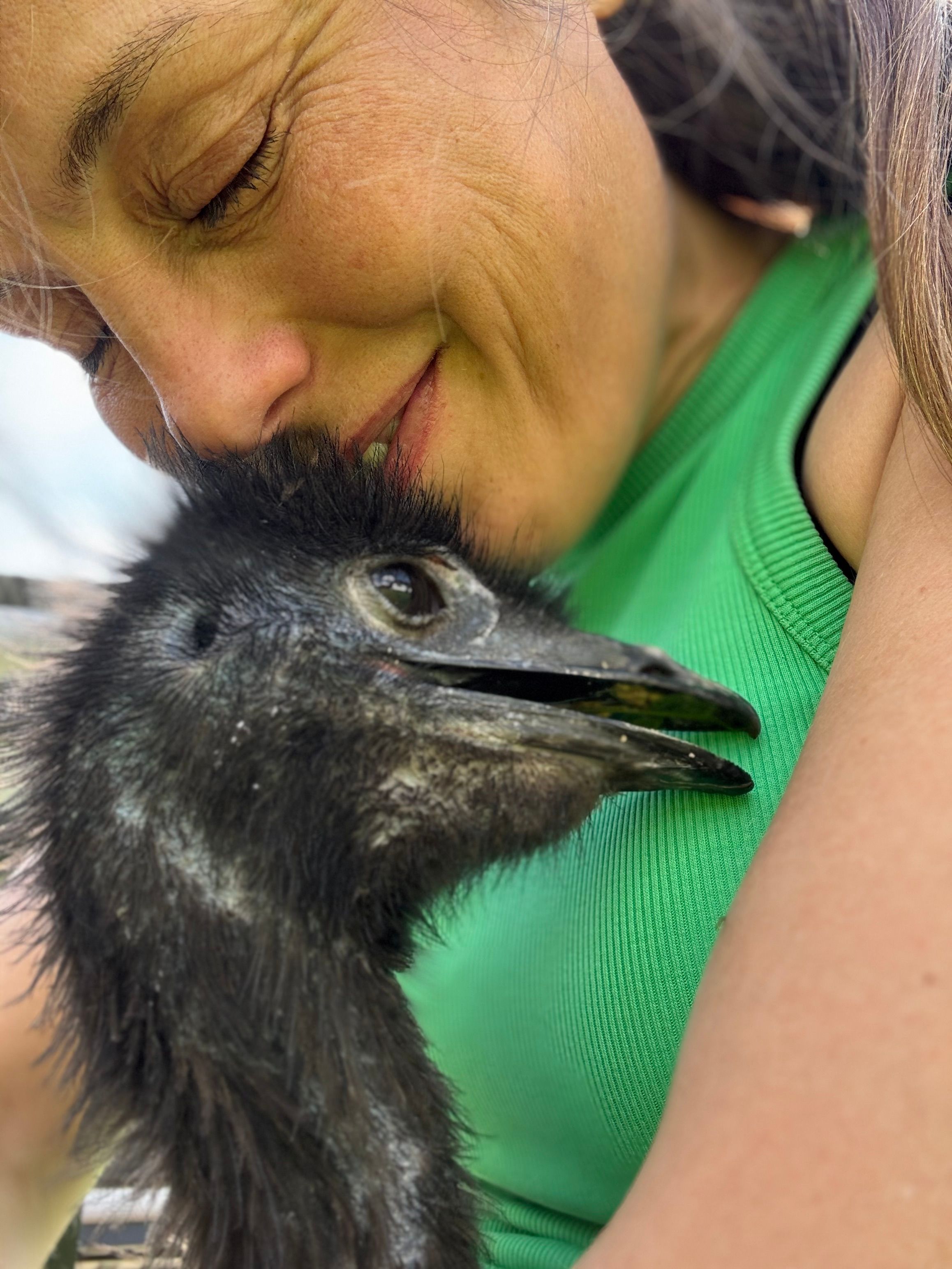 Kvinne koser med en emu