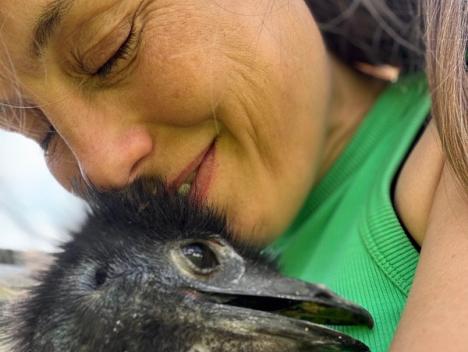 Kvinne koser med en emu