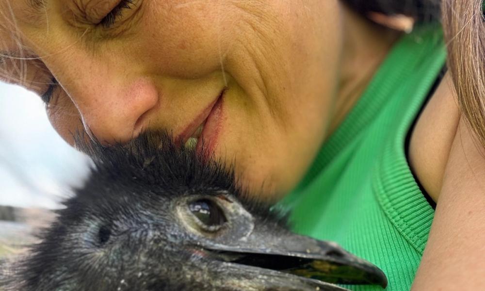 Kvinne koser med en emu