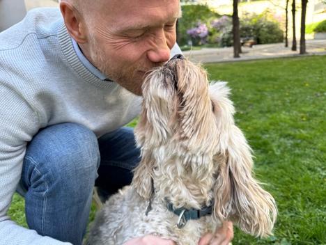 En hund stikker snuten opp i ansiktet til et menneske