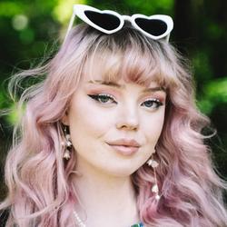 Ung smilende kvinne med rosa hår som pynter.