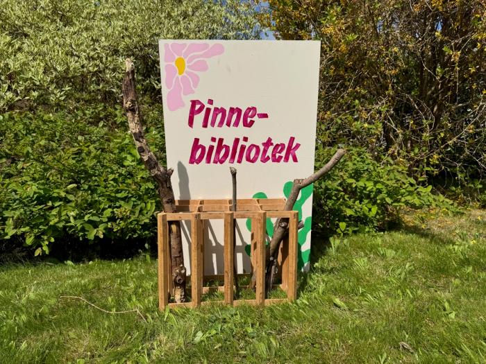 En skilt med pinnebibliotek og finner i en beholder
