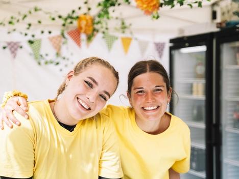 To smilende kvinner ser inn i kamera