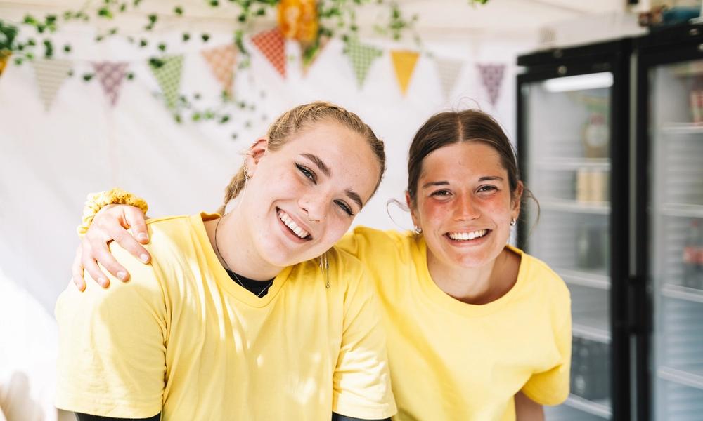 To smilende kvinner ser inn i kamera