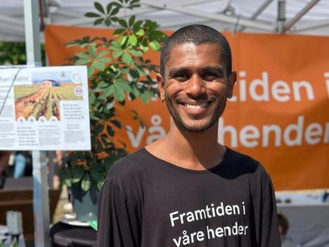 En person smiler foran standen