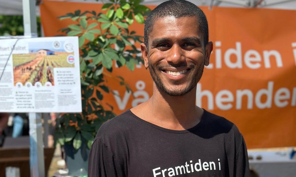 En person smiler foran standen