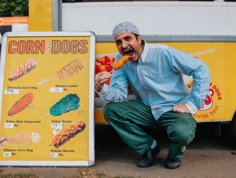 Bilde av mann som spiser corn dogs.