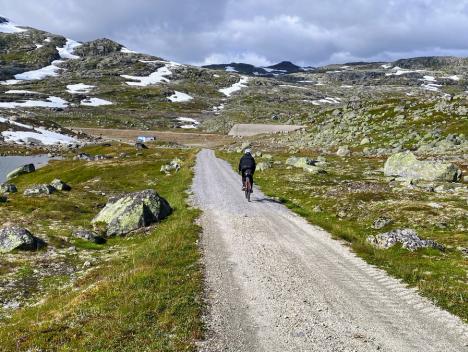 En kvinne som sykler på Rallarvegen