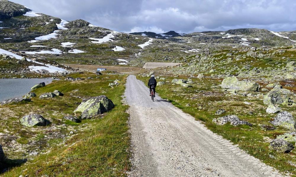 En kvinne som sykler på Rallarvegen