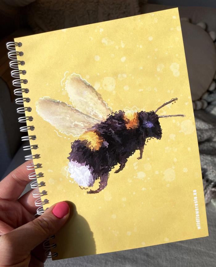 Notatbok med bilde av en fluffy bie på omslaget