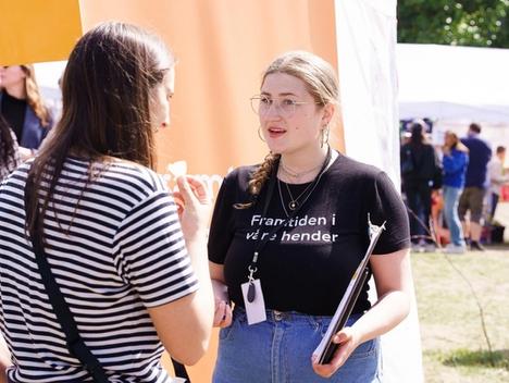 To personer snakker sammen foran Framtiden i våre henders stand. 