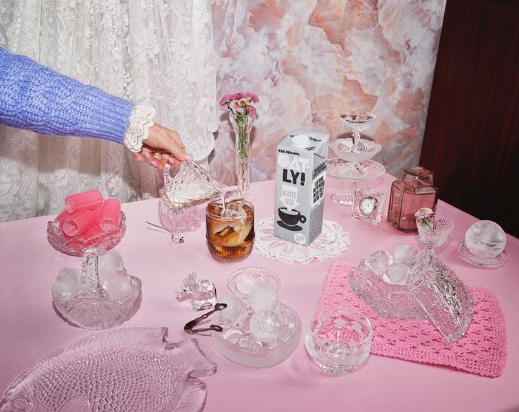 Bilde av crystallskåler og glass og en pakke med Oatly barista, som helles i et glass