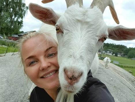 Geita Ferdinand har hodet på skulderen til Anette fra Dale Store Gård og begge ser inn i kameraet.