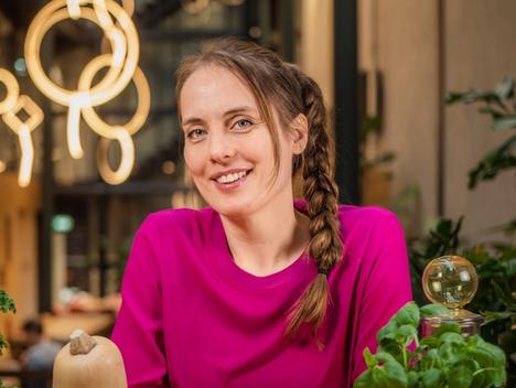 Bilde av Heidi Røneid som ser i kamera med frukt på bordet foran seg