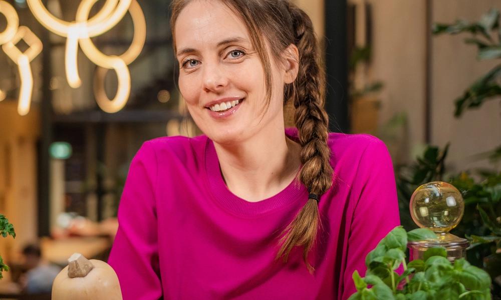 Bilde av Heidi Røneid som ser i kamera med frukt på bordet foran seg