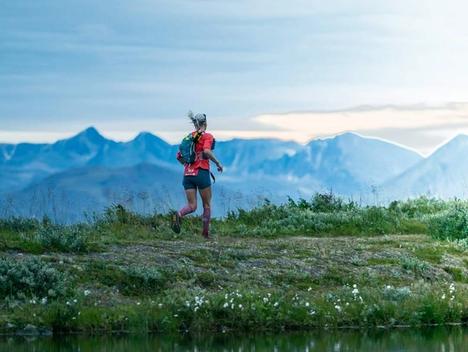 Bilde av Mari Nustad Mauland som løper på fjellet med fjell i bakgrunnen.