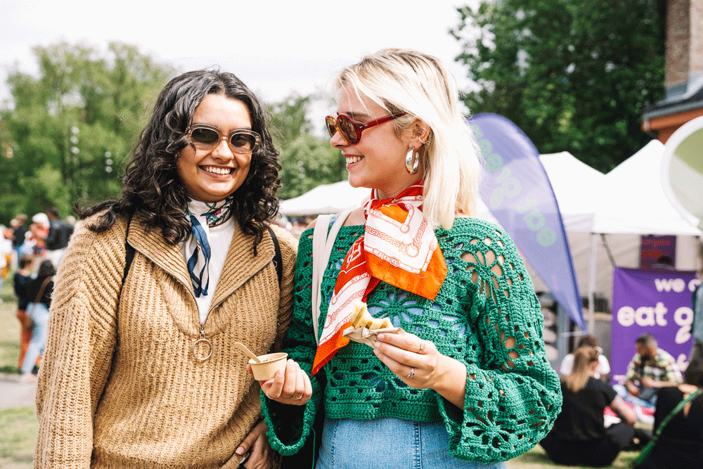 Bilde av to personer som koser seg på festivalen med mat og drikke. 