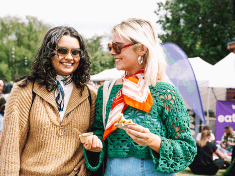 Bilde av to personer som koser seg på festivalen med mat og drikke.