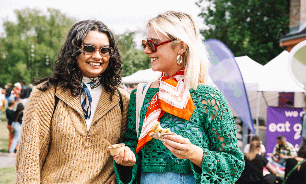 Bilde av to personer som koser seg på festivalen med mat og drikke.