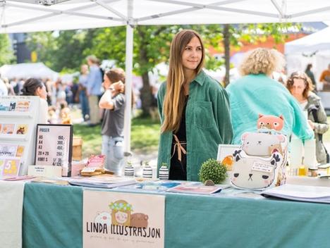 Bilde av Linda Heggen foran standen