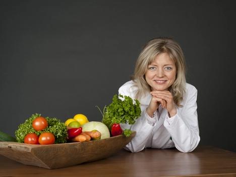 Bilde av Tanja bak et bord med grønnsaker.