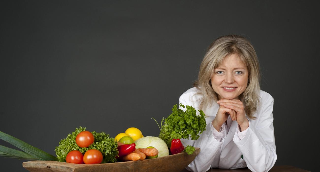Bilde av Tanja bak et bord med grønnsaker.