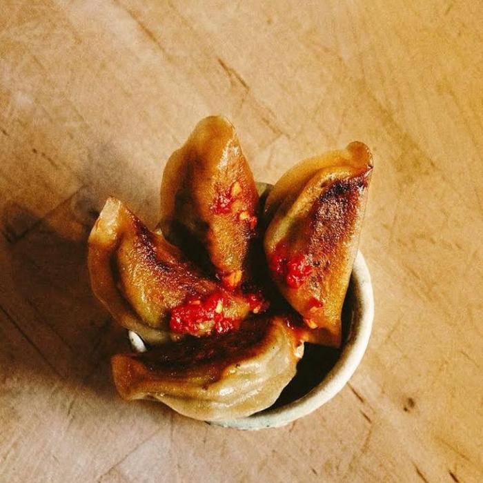 Bilde av skål med fire dumplings og rød chilisaus