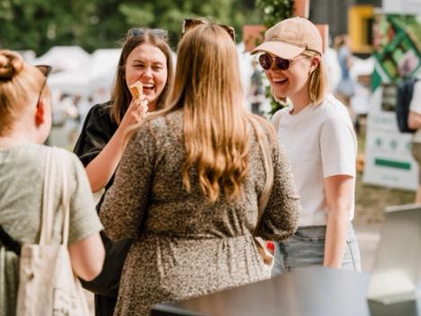 Festivaldeltagere ler og spiser is på festivalen