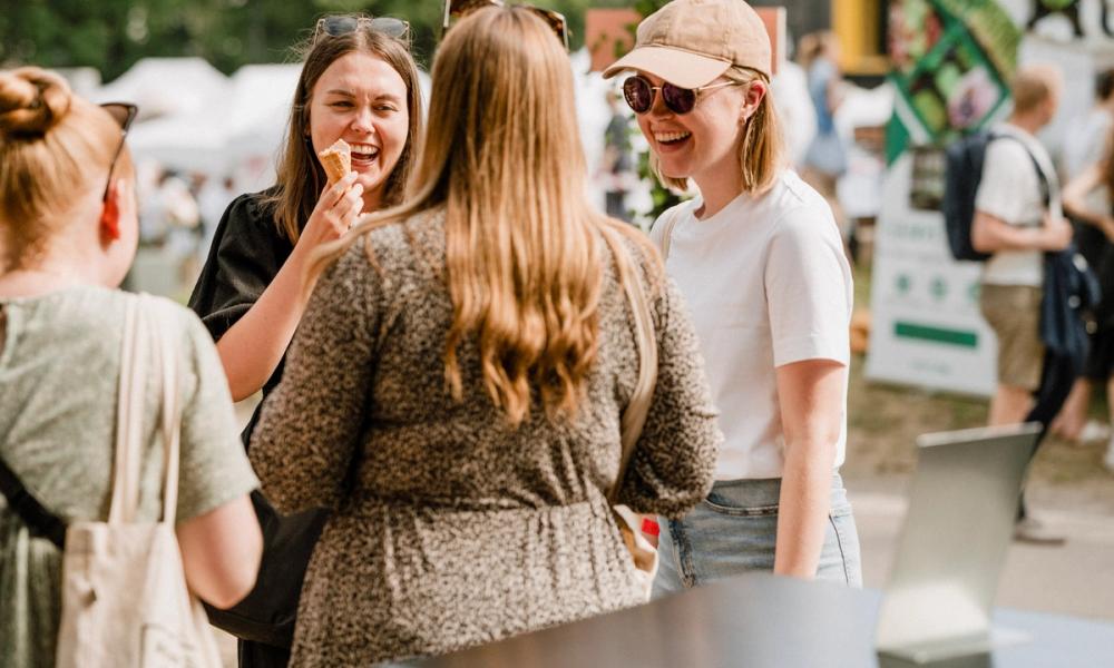 Festivaldeltagere ler og spiser is på festivalen