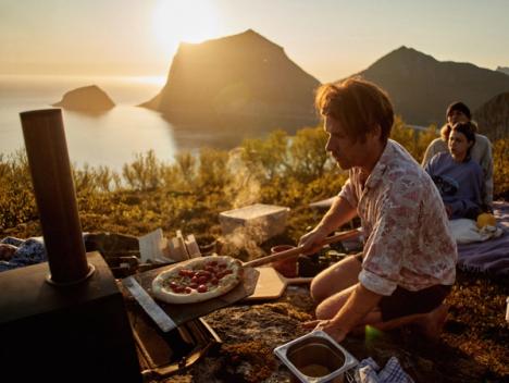 Pizza stekes ute i Lofoten med fjell i bakgrunnen