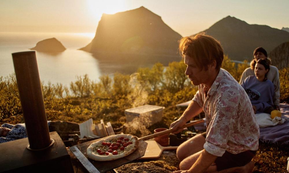 Pizza stekes ute i Lofoten med fjell i bakgrunnen