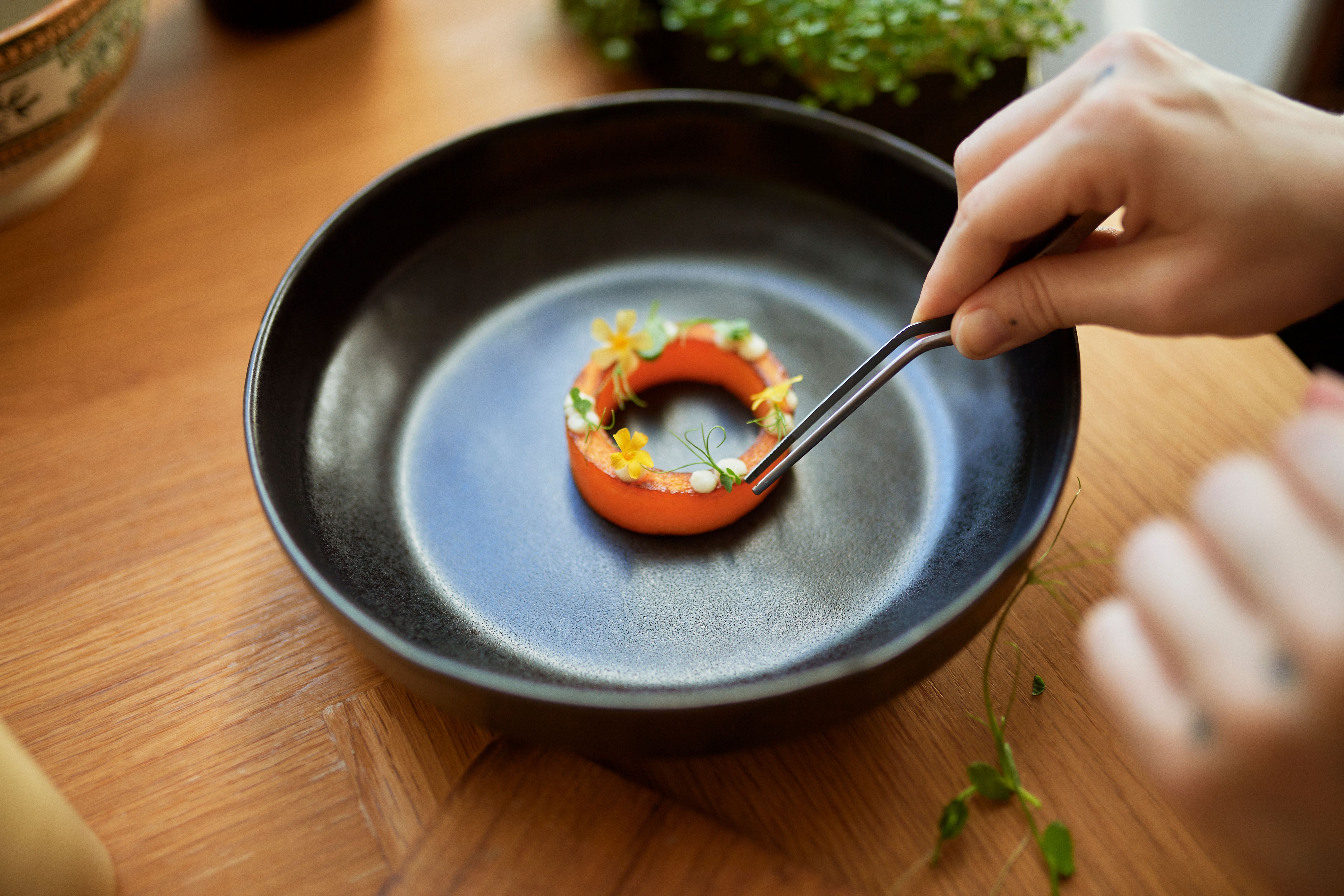 Grafikk med en tallerken med gourmetmat og bilde av Gittemarie Johansen