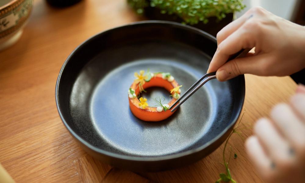 Grafikk med en tallerken med gourmetmat og bilde av Gittemarie Johansen