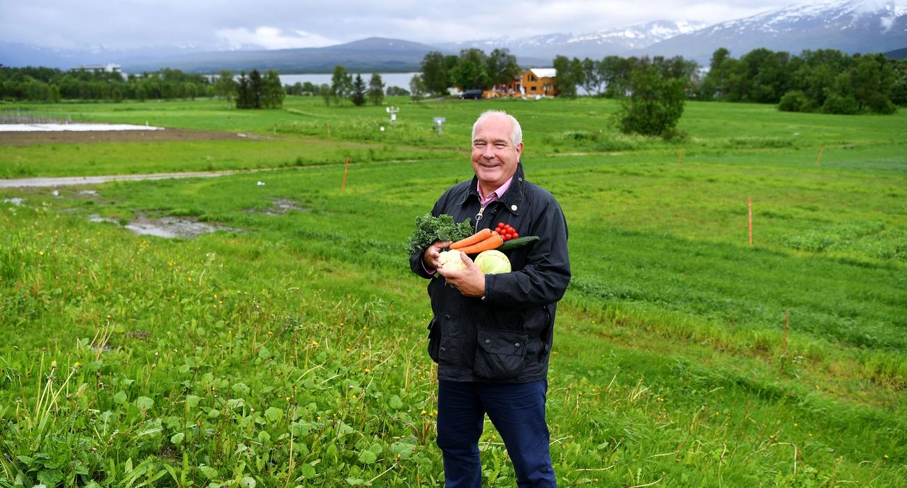 Bilde av Øyvind Fylling-Jensen fra Nofima i en åker, med grønnsaker i armene.. 