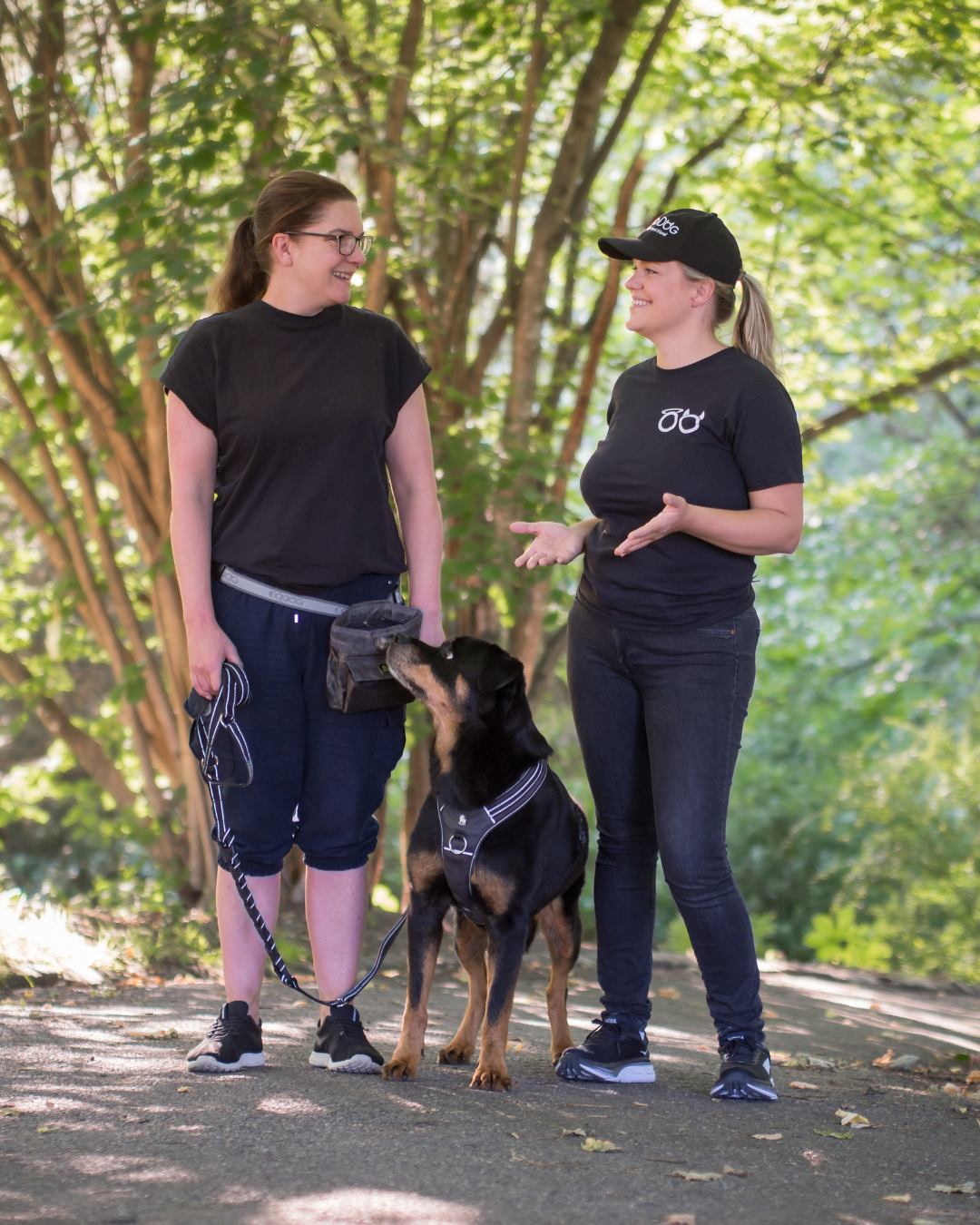 To kvinner snakker sammen og det står en hund imellom dem