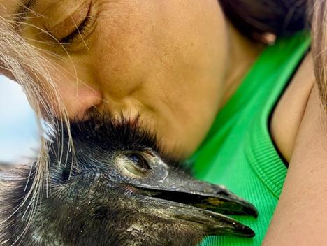 Kvinne koser med en emu